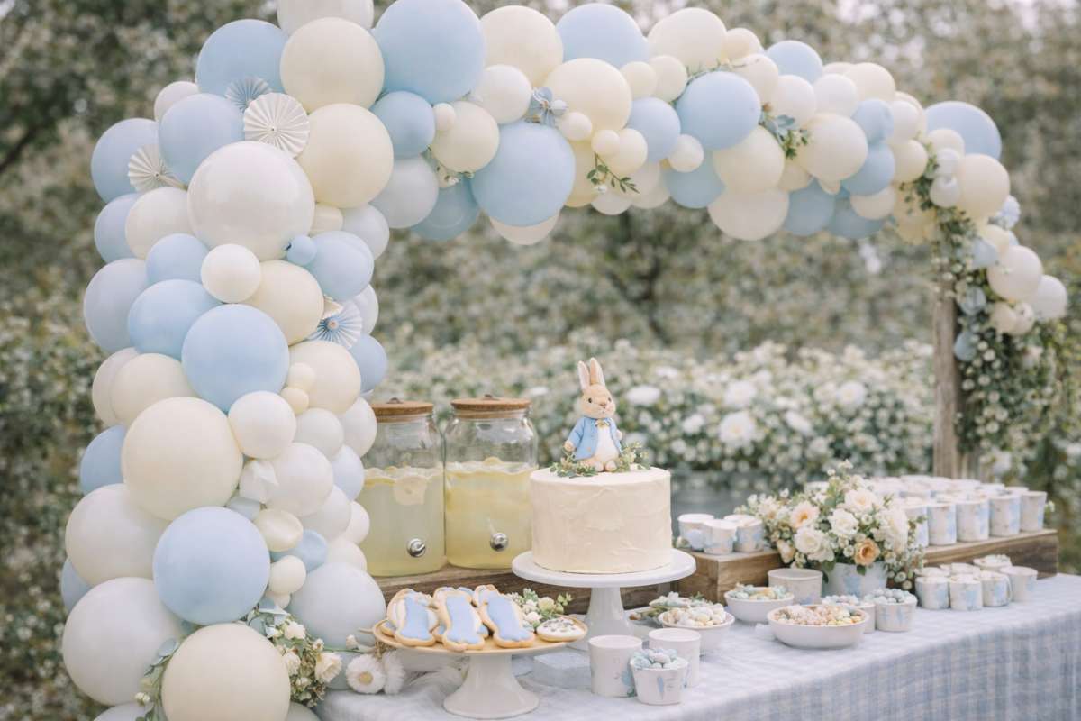 Soft blue and cream balloon garland over dessert table