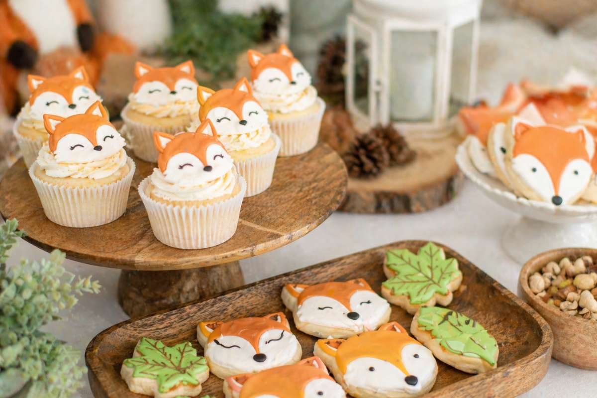 Fox-themed baby shower cupcakes and cookies with cute fox faces and woodland-inspired treats