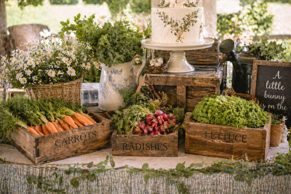 Wooden crates labeled carrots radishes and lettuce used as baby shower decor