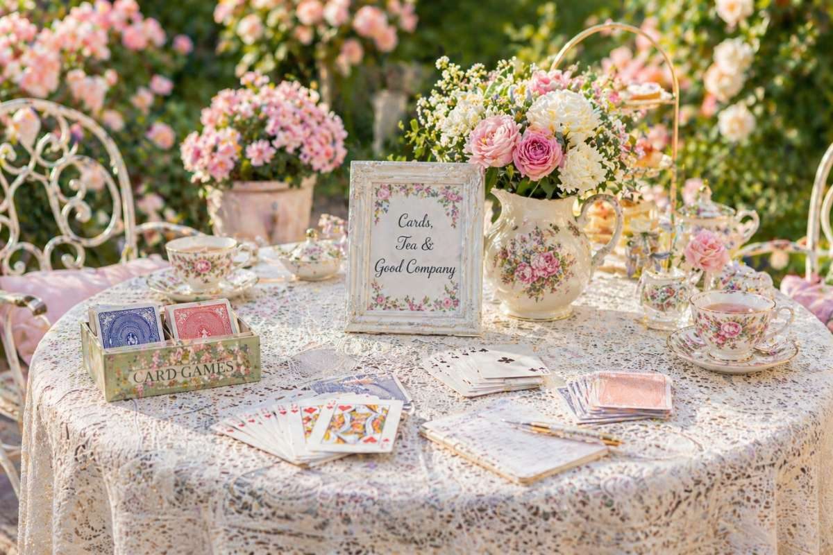 tea party game table with cards and floral decor setup