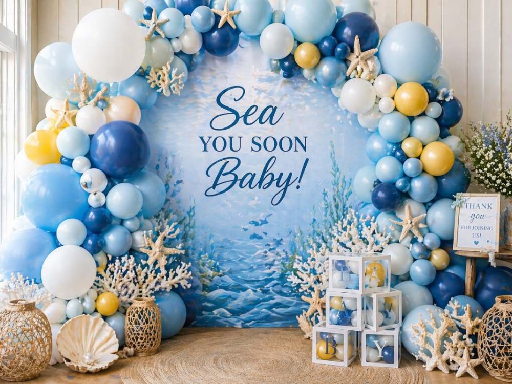 Underwater balloon arch backdrop in blue and white for Sea You Soon baby shower photos.