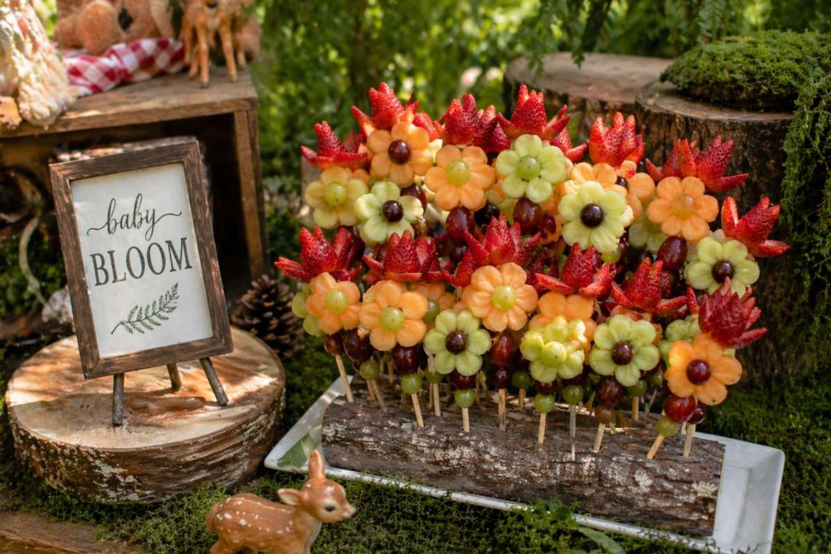 Colorful woodland fruit skewers arranged like flowers for a forest-themed baby shower